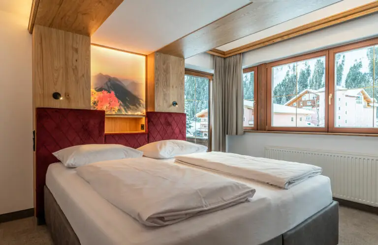 Doppelbett mit Ausblick im Zimmer Alpenrose